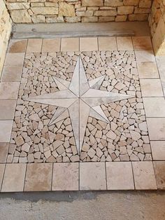 a star is on the ground in front of a stone wall and floor with cobblestones