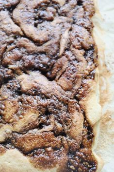 a pastry with powdered sugar on it sitting on a piece of waxy paper