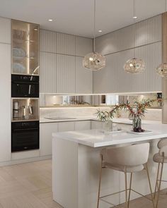 a modern kitchen with white counter tops and bar stools