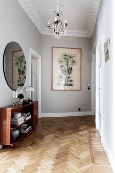 an empty room with a mirror, shelf and painting on the wall in it's corner