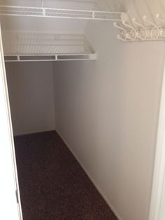 an empty closet is shown with white shelves