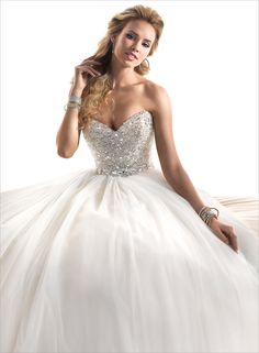 a woman in a white wedding dress is posing for the camera with her hand on her head