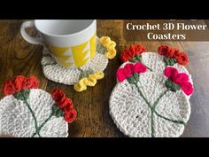 two crocheted coasters with flowers on them next to a coffee cup and mug