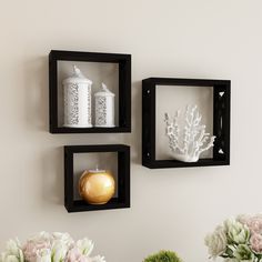 two black square wall shelves with vases and flowers