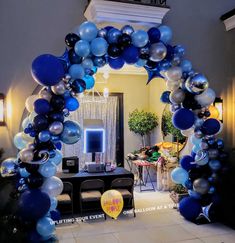 an archway decorated with blue and silver balloons