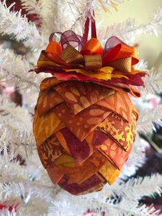 an ornament hanging from the top of a christmas tree with bows on it