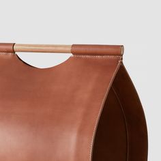 a brown leather bag with a wooden handle