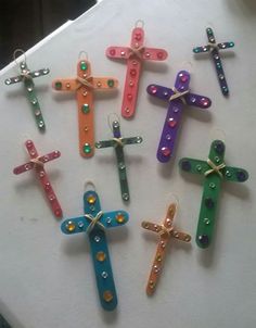 six colorful crosses are hanging on a white table with beaded accents and beads in the shape of an x