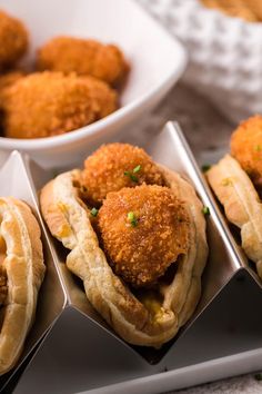 fried food items displayed in metal trays on table with bowls and utensils