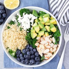 a white bowl filled with blueberries, avocado, and other food items