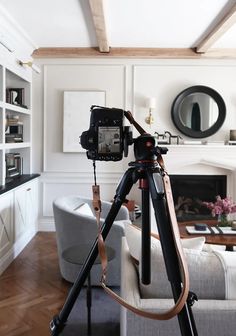 a camera sitting on top of a tripod in front of a living room filled with furniture