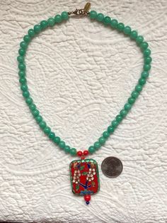 "Up for your consideration is a Vintage Cloisonne Pendant Necklace with Green Jade Peking Glass and Red Bakelite Beads. This necklace measures 17 1/2\" long and the pendant measures 2\" x 1 1/4\". If you have any questions, please don't hesitate to e-mail me and be sure to check out my other items for sale. Thanks for looking." Green Rectangular Beaded Necklace Gift, Rectangular Green Beaded Necklace For Gift, Spiritual Red Jade Jewelry, Red Amulet Beaded Necklaces With Colorful Beads, Green Beaded Rectangular Necklace, Green Rectangular Beaded Necklace, Spiritual Red Beaded Pendant Necklace, Red Hand-strung Beads For Jewelry Making, Jade Beaded Necklaces With Large Beads For Gifts