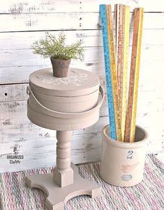 a potted plant sitting on top of a table next to a measuring tape holder