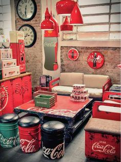 a living room filled with furniture and coca cola cans