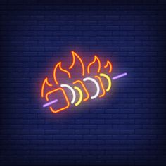 a neon sign that is lit up in the dark, with flames coming out of it