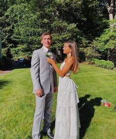 a man and woman standing in the grass