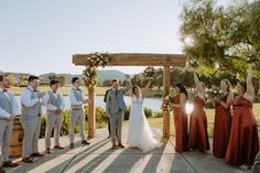 a group of people standing next to each other on a wooden platform in front of a lake