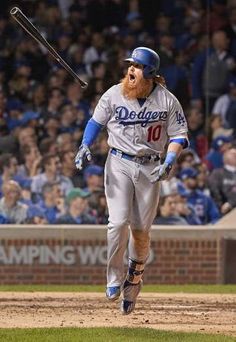 a baseball player with a beard running to first base and holding a bat in his hand