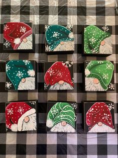 six coasters decorated with santa hats and snowflakes on a checkered tablecloth