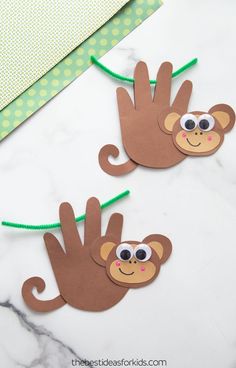 two hand puppets made to look like monkeys on a marble counter top with green string