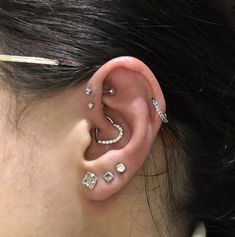 a woman wearing ear piercings with diamonds