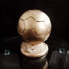 a golden soccer ball sitting on top of a table