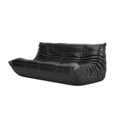 a black leather couch sitting on top of a white floor