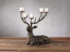 a deer figurine with four candles in it's antlers on a wooden table