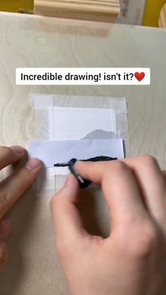 someone is drawing something on the paper with their fingers and using scissors to cut it