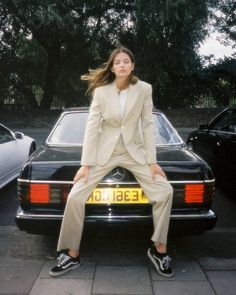 a woman sitting on the back of a car