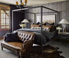 a bedroom with a four poster bed and leather chair