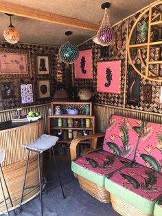 a living room with wicker furniture and pictures on the wall above it's bar