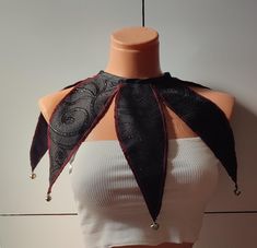 a mannequin wearing a white top with black and red scarves on it