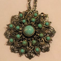 -Antique Sliver color Turquoise Pendant Necklace -Chain length: 24 in -Pendant size: 1.75 in -Biggest turquoise size: 9 mm -Smallest turquoise size: 3 mm -The part that connect the pendant and the chain have a little part missing -Needed to be clean Vintage Blue Flower Pendant Necklace, Vintage Turquoise Pendant Necklace With Patina, Handmade Turquoise Metal Necklace, Vintage Turquoise Necklace With Large Pendant, Handmade Metal Turquoise Necklace, Vintage Turquoise Jewelry With Large Pendant, Blue Turquoise Necklace With Oxidized Finish As Gift, Turquoise Necklace With Vintage Charm As Gift, Turquoise Necklace With Vintage Charm For Gift