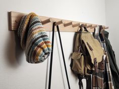 a coat rack with several purses hanging from it and two bags on the wall