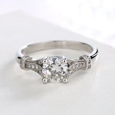 This Sterling Silver Vintage Engagement Ring, adorned with crystals from Swarovski, captures the essence of timeless romance and elegance. The ring features a sterling silver band, intricately designed with vintage-inspired patterns that evoke the charm of a bygone era. At its heart, a stunning crystal from Swarovski takes center stage, sparkling with a brilliance that mirrors the depth of true love. Surrounding the central crystal, a series of smaller Swarovski crystals add an extra layer of da Necklaces Dainty, Classic Engagement Ring, Layering Necklaces, Classic Engagement, Vintage Engagement Ring, Classic Engagement Rings, Popular Jewelry, Current Styles, Statement Necklaces