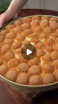 a person holding a pan filled with bread