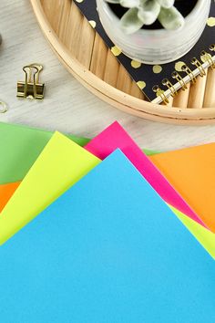 many different colored papers on a table next to some scissors and other crafting supplies