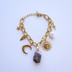 Embrace your mystical side with our Witchy-Themed Gold Plated Charm Bracelet. This enchanting piece features a stunning amethyst statement charm and a collection of magical symbols, perfect for the modern witch. Measuring 6 inches with a 1-inch extender chain, it offers a perfect fit and a touch of elegance. Crafted with gold plating, this bracelet is designed to add a hint of enchantment to any outfit. Witchy Gold Jewelry, Gold Celestial Jewelry With Charms, Mystical Gold Charm Necklace Gift, Witchy Bracelet, Luxury Mystical Moon Charm Jewelry, Witchy Products, Adjustable Gold Celestial Charm Bracelet, Witch Charm Bracelet, Witch Bracelet