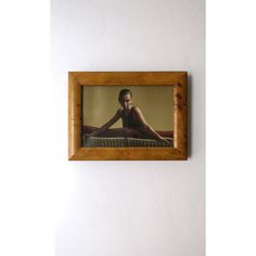 a framed photograph of a woman sitting on a bed