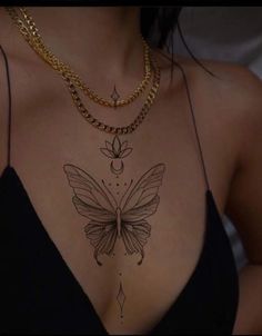 a woman's chest with a butterfly tattoo on the top and bottom part of her body