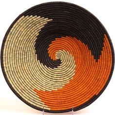 an orange and black woven basket on a white background