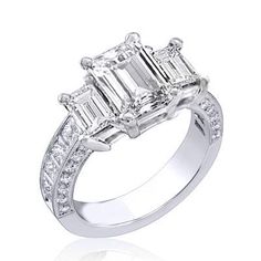 a three stone diamond ring set in 18k white gold with diamonds on each side