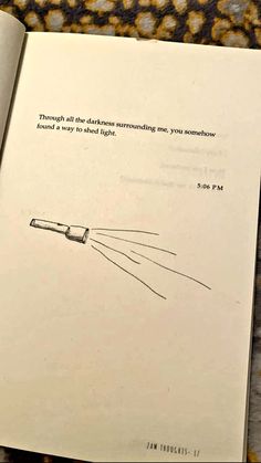 an open book with a drawing of a light coming out of it's end