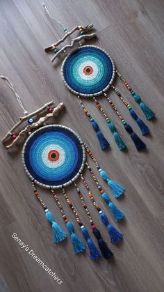 two crocheted dream catchers with tassels and beads on the floor