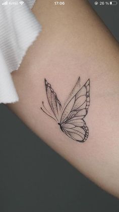 a small butterfly tattoo on the arm