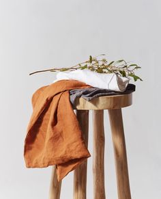 an orange blanket is sitting on top of a wooden stool