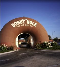 a car is parked in front of the entrance to donut hole with its logo on it