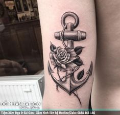 an anchor and rose tattoo on the left arm is shown in black and grey colors