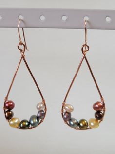 Beautiful teardrop earrings created with the rainbow in mind. Perfect for LGBTQIA+ events or for just enjoying the many different colors of pearls. This design comes with two different metals for the frame and ear wires. Aluminum is both sturdy and light making these comfortable to wear. Copper is still fairly light though slightly heavier than Aluminum but has a more interesting luster and will show age over time.  The stones are real freshwater pearls. I handmake all of these with natural materials so there may be some variation in size, shape, and color. Elegant Multicolor Teardrop Hoop Earrings, Teardrop Pearl Earrings With Metal Ear Wire, Elegant Multicolor Teardrop Earrings, Wire Wrapped Pearl Teardrop Earrings, Metal Teardrop Pearl Drop Earrings, Multicolor Pearl Drop Earrings, Pearl Teardrop Earrings, Rainbow Pearl, The Rainbow